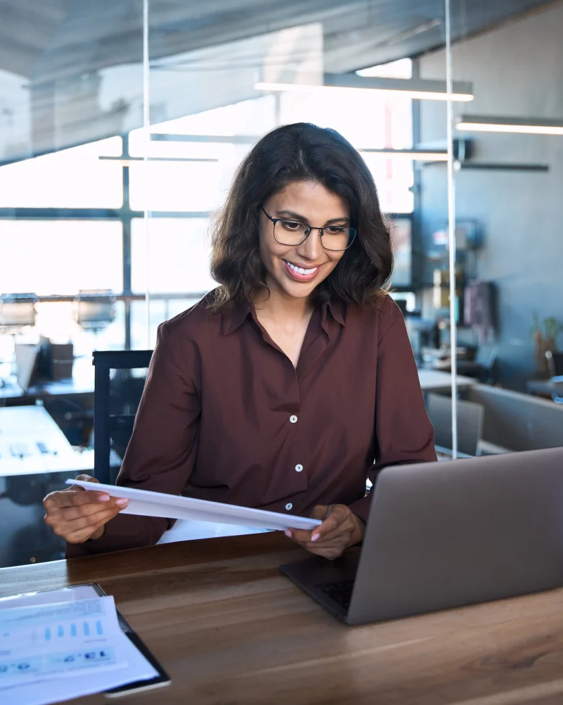 nimbus workforce scheduling software - woman sitting at her desk on laptop in office